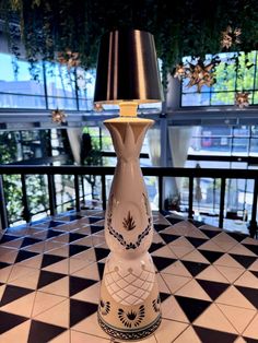 a lamp sitting on top of a table next to a black and white checkered floor