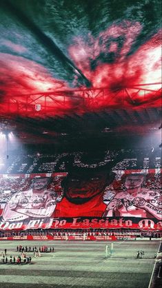 a large stadium filled with lots of red and white banners on the side of it