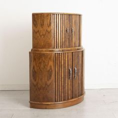 a tall wooden cabinet sitting on top of a white floor