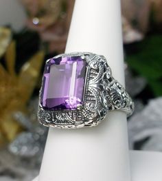 Natural Purple Amethyst Ring Intricate Design#149 Custom Made Inspired by Victorian era designs, I now offer this lovely filigree reproduction in sterling silver. This is a flawless natural purple amethyst is 12mm by 10mm in Length & Width. The ring is 3/4th of an inch North/South on the finger. The inside of the band is etched 925. Notice the intricate and detailed Victorian design of the antique patina silver filigree setting all the way down the band. This is an exquisite rendition of an Purple Amethyst Ring With Intricate Design, Amethyst Rings With Intricate Design For Wedding, Purple Diamond Cut Jewelry For Wedding, Purple Hallmarked Art Deco Amethyst Ring, Purple Anniversary Rings With Intricate Design, Art Deco Purple Amethyst Ring, Fine Jewelry Amethyst Ring With Intricate Design For Anniversary, Fine Jewelry Amethyst Ring With Intricate Design For Wedding, Intricate Design Amethyst Ring For Wedding