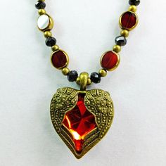 This beautiful deep red beaded necklace is OOAK. It measures 22 inches around. I used FLat red oval glass beads with a golden edge, black crystal beads, and round brass beads as spacers to give it a steampunk Victorian look. The red glass heart with brass wings pendant completes the vintage looking romantic theme.  The clasp is an easy to operate brass lobster claw clasp.  A perfect gift for a woman who loves rich sparkling red! I ship quickly. I accept Paypal and I will mail this necklace in a padded envelope in a gift box. Red Heart-shaped Beaded Necklaces, Red Heart-shaped Beaded Necklace, Red Czech Glass Spiritual Jewelry, Red Heart-shaped Beaded Necklace Gift, Red Spiritual Necklace With Heart Beads, Spiritual Red Necklace With Heart Beads, Spiritual Red Jewelry With Black Beads, Red Beaded Spiritual Crystal Necklace, Red Spiritual Jewelry With Black Beads