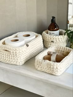 two white baskets with toiletries on a counter