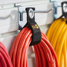 several different colored cords are hanging on the wall next to each other and attached to hooks