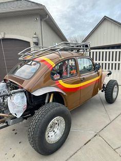 a car that is parked in front of a house with its hood up and the engine out