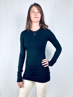 This crew neck tee is made fitted and with extra long bodice and sleeves for some stacking effect. Made with 66% bamboo, 28% organic cotton, 6% spandex jersey, it has a very soft feel with an elegant and stylish look. Wear it with your everyday jeans or dress it up with a chic trouser or dressy skirt and some jewelry. Also great for layering under a blazer, sweater or a sleeveless dress. Available in black and off white.Size Chart:Small Bust 33-36", waist 25-28", hips 36-39"Medium Bust 37-40", w Fine Knit Stretch Crew Neck T-shirt, Fitted Long Sleeve Top For Layering, Stretch Long Sleeve T-shirt With Thumbholes, Long Sleeve Tops With Thumbholes, High Stretch Casual Long Sleeve Top For Layering, Long Sleeve Tops With Thumbholes And Minimal Stretch, Fitted Long Sleeve Top With Thumbholes Crew Neck, Fitted Tops With Thumbholes For Everyday Wear, Solid Crew Neck Top With Thumbholes