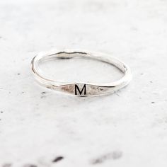 This dainty and charming ring is hand-crafted from high-quality sterling silver, ensuring both durability and style. Choose your favorite initial to be hand stamped on the ring, making it a delightful and meaningful gift for yourself or someone special. With meticulous precision, we create a unique design that adds a playful flair to the ring's overall allure. Express your individuality and show off your style by stacking this fabulous Sterling Silver Initial Ring with other favorites. Whether y Personalized Silver Ring With Meaningful Style, Adjustable Initials Stackable Rings For Everyday, Everyday Adjustable Stackable Rings With Initials, Personalized Meaningful Sterling Silver Rings, Meaningful Personalized Sterling Silver Rings, Personalized Dainty Initial Ring, Minimalist Stackable Initial Ring For Anniversary, Dainty Personalized Initial Ring With Round Band, Adjustable Stackable Initial Ring