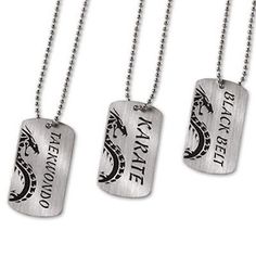 three dog tags with dragon on them hanging from a ball chain, one is silver and the other is black