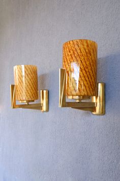 two wall sconces mounted to the side of a white wall next to each other