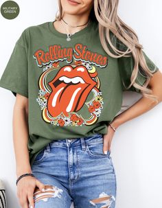 Step back in time and rock out in style with our Vintage Flower Rolling Stone Tee! 🌸🎸 This retro-inspired t-shirt features a classic Rolling Stone logo beautifully intertwined with vibrant flowers, capturing the free-spirited essence of rock 'n' roll and the timeless charm of the 70s. 🌼✨ Crafted from super-soft, high-quality fabric, this tee offers ultimate comfort and a perfect fit, making it an essential addition to your wardrobe. Whether you're heading to a concert, a festival, or just channeling your inner rock star, this tee will have you looking effortlessly cool and totally groovy. 🌟👕 Get ready to roll and bloom with style! 🌿🎶🛒 Retro Green Printed T-shirt, Retro Graphic Print T-shirt For Spring, Hippie Crew Neck T-shirt For Fall, Retro Fall Concert T-shirt, Retro T-shirt For Fall Concert, Graphic Tee For Spring Music Festival, Hippie Graphic Print Top For Music Festival, Groovy Summer Streetwear Tops, Spring Music Festival Graphic Tee