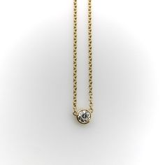 This 14k gold diamond necklace is a classic everyday piece and a great staple for any jewelry collection. The Old European Cut diamond has a lot of sparkle—its facets create excellent light play that pops when worn. The bezel setting is simple and the width of the chain balances the diamond well. This is a vintage piece, circa 1990’s, that contains a much older antique diamond. The perfect combination of old and new.  The natural antique diamond is Old European Cut, VS2 in clarity and I-J in color. It measures 5 mm across and weighs approximately .4 of a carat.   The chain measures 16 1/4”. It is marked 14k, ITALY, and with the maker’s mark “Fancy”. The necklace weighs 2.8 grams. Minimalist 14k Gold Diamond Necklace With Bezel Setting, Classic Diamond Birthstone Necklace For Formal Occasions, Formal Classic Birthstone Necklace With Diamond Accents, Formal Classic Diamond Birthstone Necklace, Yellow Gold Solitaire Necklace In 14k Brilliant Cut, Yellow Gold 14k Solitaire Necklace With Brilliant Cut, Classic Yellow Gold Solitaire Necklace With Single Cut Diamonds, Classic Formal Birthstone Necklace With Brilliant Cut, Yellow Gold Solitaire Necklace For Everyday