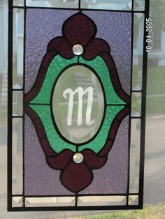 a stained glass window with the letter m on it