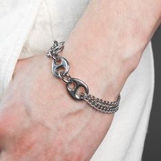 DESCRIPTION: This Pluto bracelet is robust yet comfy. It is made of tarnish resistant stainless steel and finished with a swivel lobster clasp closure. Unique polished liquid like links and a looped rounded curb chain come together with thoughtful construction. Available in four sizes, this bracelet is made just for you. DETAILS: available in 4 sizes 1.5 adjustable tail chain Rhodium plated Hematite stone stainless steel grunge aesthetic modern futuristic unisex FIT: Model has a 7 inch wrist and Modern Stainless Steel Cuban Link Bracelet With Adjustable Chain, Modern Metal Cuban Link Chain Bracelet, Modern Metal Cuban Link Bracelet, Modern Cuban Link Metal Bracelet, Modern Stainless Steel Chain Bracelet With Solid Links, Modern Stainless Steel Cuban Link Bracelet For Everyday, Metal Cuban Link Bracelet With Oval Links, Everyday Metal Chain Bracelet With Stainless Steel Clasp, Modern Metal Bracelets With Curb Chain