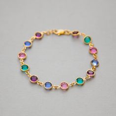 "Dainty, custom Mother's bracelet in gold with Swarovski Crystal birthstones. This sparkling birthstone bracelet would make a perfect gift for a mother or grandmother, with Swarovski crystals, set in gold, representing the birthstones of their family members. I can make this bracelet in a variety of ways for you. The photos above show some of the options: * a row of birthstones surrounded on either side by clear crystals * a repeated pattern of colors * a single color <>How to Order<&gt Gold Name Bracelet With Birthstone For Birthday, Gold Crystal Bracelet For May Birthstone Gift, Gold Gemstone Bracelet For Birthday, Gold Crystal Birthstone Bracelet As Gift, Multicolor Gold Bracelet For Gift, Gold Bracelets For Anniversary With May Birthstone, Yellow Gold Birthstone Bracelets For Birthday, Yellow Gold Birthstone Bracelet For Birthday, Gold Birthstone Bracelets For Anniversary