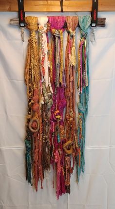 there are many scarves hanging on the wall