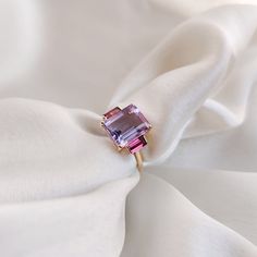 This stunning ring is set in 14k Solid Yellow Gold with Natural Pink Amethyst & Rhodolite Garnet with utmost precision. It is an unique statement gemstone ring for nearly every occasion and is completely hassle-free jewelry. ITEM DETAILS * CENTER GEM: Pink Amethyst  * GEM SIZE: 8X10mm * GEM SHAPE: Octagon (Emerald Cut) * SIDE GEM: Rhodolite Garnet * GEM SIZE: 2.5x5mm (2pc) * GEM SHAPE: Baguette * Gem Weight: 3.65 carats * Gold Purity: 14KT * Gold Weight: 1.61 gram * Total Weight of the Ring: 2.34 gram The Gold purity is guaranteed and it comes with authentic 14KT gold hallmark. Since my items are handmade, they are absolutely nickel and lead free. CUSTOMIZATION * Gemstone customization is available, it can be substituted with a gem of your choice. Kindly drop me a message for the same! PAC Amethyst And Garnet, February Birthstone Ring, Rhodolite Garnet Ring, Handmade Jewelry Box, Garnet Gem, Gold Gemstone Ring, Amethyst Gem, Higher Consciousness, Garnet Ring