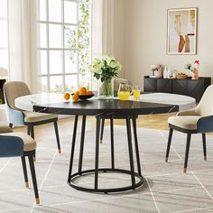 a dining table with chairs around it in the middle of a living room filled with furniture