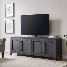 a flat screen tv sitting on top of a wooden entertainment center in a living room