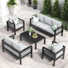 a set of outdoor furniture sitting on top of a cement floor next to a potted plant