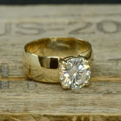 a diamond ring sitting on top of a piece of wood