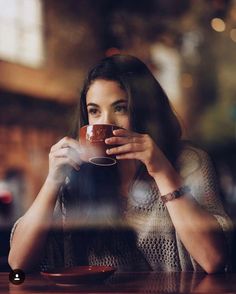 a woman holding a coffee cup in her right hand