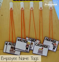 an employee name tags are hanging on a bulletin board with clothes pins attached to them