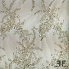 Couture Floral Beaded Netting - Ivory/Silver (Bridal) Color - White Ivory Silver Width - 50/51” Fabric Care - Dry Clean Only Traditional White Embellished Wedding Dress, Elegant Gold Wedding Dress With Zari Work, Elegant Gold Wedding Dress For Festive Occasions, Festive Embellished White Wedding Dress, Cream Embroidered Fabric For Festive Formal Occasions, Festive Wedding Pearl Embroidered Fabric, Festive Cream Embroidered Fabric For Formal Occasions, Formal White Wedding Dress With Pearl Embroidery, Elegant White Beaded Embroidered Fabric