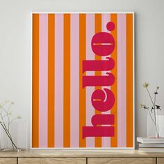 an orange and pink poster with the word love on it in front of a white wall