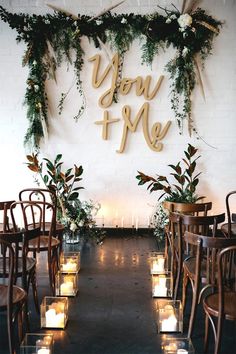 a table with chairs and candles in front of a sign that says you me on the wall