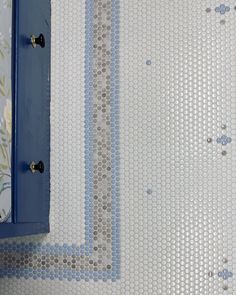 a bathroom with blue and white tiles on the wall