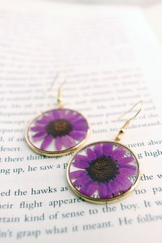 These lovely earrings are made from multiple layers of resin and deep pruple daisy flowers.Earrings are very lightweight and comfortable. Since real flowers are used for this piece, please note that there will be some variations in the flowers. However, this is what makes each piece unique and one of a kind. Size: About 1.5" (2" with hooks) Floral Resin, Flowers Earrings, Purple Daisy, Daisy Earrings, Daisy Flowers, Lovely Earrings, The Flowers, Real Flowers, Daisy Flower