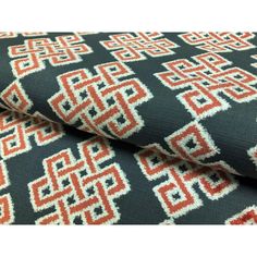 an orange and black patterned fabric with white, red and blue geometric designs on it