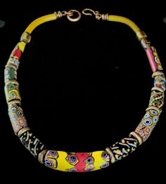 A bold necklace of colorful 19th c. Venetian millefiori and decorated glass trade beads and thick Nigerian sand-cast brass rings on sturdy vintage brass chain.  All of the elements have acquired a beautiful patina of age and are in excellent condition.  There is a visible chip on the end of one of the matched beads, but I don't believe that this detracts from the integrity or beauty of the piece. The rustic brass rings used as spacers are sand cast by hand in Nigeria; no two are identical. The n Artisan Glass Jewelry With Large Beads, Collectible Bohemian Multicolor Necklace, Traditional Multicolor Collectible Necklaces, Multicolor Bohemian Collectible Necklace, Bohemian Multicolor Collectible Necklaces, Bohemian Multicolor Collectible Necklace, Handmade Traditional Murano Glass Jewelry, Bohemian Jewelry With Polished Murano Glass Beads, Bohemian Murano Glass Jewelry With Polished Beads