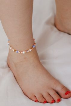 This beaded anklet is the perfect boho pop of beach colors and the pearls give it the most gorgeous shine. A must for your next vacation, you will get so many compliments. The best part is that you won't find better quality and the colors won't rub off in the ocean or pool. Grab yours today! Be sure to measure to get the best fit! Spring Beach Bracelets With Tiny Beads, Summer Beaded Pearl Bracelet With Round Beads, Hypoallergenic Beaded Bracelets For Summer, Bohemian Pearl Bracelet For Summer Gifts, Cute Beaded Bracelets For Beach In Summer, Beaded Anklets As Beach Season Gift, Beaded Strand Friendship Bracelets For Summer, Summer Beaded Strand Friendship Bracelets, Adjustable Pearl Bracelets For Summer