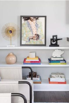 a living room with a couch, chair and bookshelf on the wall in front of it