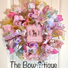 a pink and gold christmas wreath with the words, the bowtiquee on it