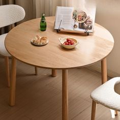 a wooden table with two plates of food on it and a book next to it