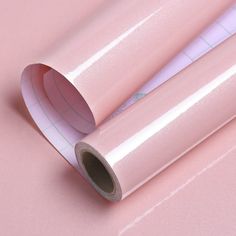 two rolls of pink wrapping paper sitting on top of each other next to one another