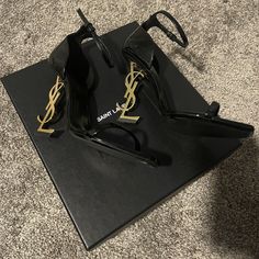 Yves Saint Laurent Black Opyum 110 Sandals Ankle Strap In Patent Leather With Gold-Tone. Preowned Signs Of Wear 2-3 Times Only. Condition Like New. Excellent Condition. Comes With Original Box W/ Dust Bag + Small Envelope. Size: 38.5 (Us Size: 8.5) Made In Italy Authentic 100% Retail $1,290 Purchased At Ysl Store. (Proof Of Purchase If Needed) Free Shipping + Final Sale!! + No Returns!!! Sandals With A Structured Heel Decorated With Metal Ysl Initials And Featuring An Adjustable Ankle Strap. 100 Ysl Store, Small Envelope, Shoes Heels Classy, Ysl Heels, Yves Saint Laurent Shoes, Paint Wall, Vintage Ysl, Ysl Shoes, Dream Outfits