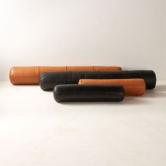 three black and orange leather couches sitting next to each other on a white surface