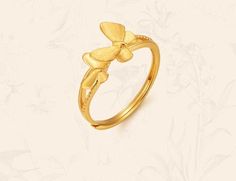 a gold ring with a flower on the front and side, sitting on a white background