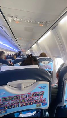 the inside of an airplane with people sitting on seats