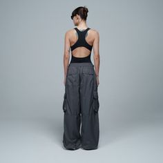 One of our iconic garments returns in this collection, these parachute pants are made of anti-fluid fabric, have a rolled waist and boots for a comfortable fit, adjustable drawstring on the sides, pockets with lids and a detail with the True logo on one of the pocket covers. This garment is unisex, it can be combined with basic t-shirts, slim tees, short long-sleeved shirts or air fit from this collection.Length: S: 41.7'' | M: 42.1'' | L: 42.5'' | XL: 42.9'' Functional Wide Leg Cargo Parachute Pants, Athleisure Wide-leg Parachute Pants With Pockets, Loosely Fitted Wide-leg Utility Parachute Pants, Loosely Fitted Parachute Pants With Cargo Pockets, Nylon Wide Leg Cargo Parachute Pants, Nylon Long Pants With Functional Drawstring, Athleisure Parachute Pants With Loosely Fitted Hips And Pockets, Nylon Wide-leg Pants For Streetwear, Athleisure Parachute Pants With Loosely Fitted Hips