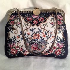 A Fantastic 1950s Vintage Tapestry Handbag / Purse this beautiful vintage piece has a great detailed floral pattern on a cream background which is surrounded by a black broader. The Frame of this Fantastic Vintage Tapestry Bag / purse has a gold frame metal with a Fantastic detail on the frame. This Fantastic Vintage Bag has a simple gold clasp and a short gold coloured chain, this Great Tapestry bag is fully lined in black with a small inside pocket Label  - N/A  Measurements :  Approximately  Width   -   7- 3 Inches ( measured in the middle of the bag )   Lenght  -   6- Inches   Condition -  Great Vintage Condition A Great Vintage Piece for ALL you Great Vintage Lovers.                            We ship Worldwide PLEASE request a shipping quote for All purchases outside of the UK,  Than Vintage Embroidered Rectangular Evening Bag, Vintage Tapestry Bag, Vintage Embroidered Tapestry Shoulder Bag, Antique Tapestry Evening Bag, Vintage Embroidered Clutch Evening Bag, Elegant Rectangular Shoulder Bag In Vintage Style, Vintage Evening Bag In Tapestry Material, Vintage Tapestry Bag For Evening, Vintage Embroidered Formal Bags