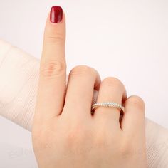 a woman's hand with a red manicure and a ring on her finger