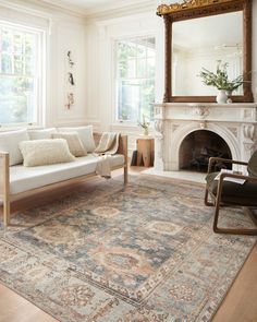 a living room filled with furniture and a large rug on top of a hard wood floor