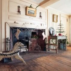 a living room filled with furniture and a fire place in front of a christmas tree