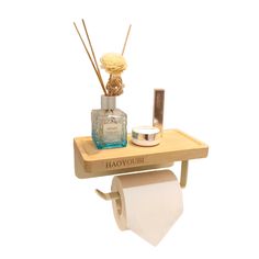 a wooden shelf with two rolls of toilet paper on it and a bottle of perfume next to it