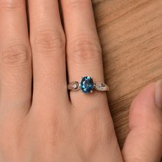 It is a London blue topaz ring. The main stone is 6 mm*8 mm oval cut.weight about 1.47 carats. The basic metal is sterling silver and plated with rhodium. To change the metal to a solid gold (white/rose) or platinum is also available, please ask for a quotation if you want. You can also go to my shop Home for more elegant rings: https://www.etsy.com/shop/godjewelry?ref=hdr_shop_menu London blue topaz is the November birthstone. More London blue topaz rings: https://www.etsy.com/shop/godjewelry?s Oval Blue Topaz Diamond Ring Gift, Oval Blue Topaz Diamond Ring As Gift, Fine Jewelry Oval Blue Topaz Diamond Ring, Fine Jewelry Blue Topaz Diamond Ring, Blue Oval Birthstone Ring In Sterling Silver, Blue Oval Sterling Silver Birthstone Ring, Elegant Oval Blue Topaz Birthstone Ring, Anniversary Oval Blue Topaz Diamond Ring, Oval Blue Birthstone Ring With Center Stone