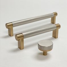 two brass and silver metal handles with knobs on each side, against a white background