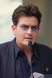 a man wearing glasses speaking into a microphone